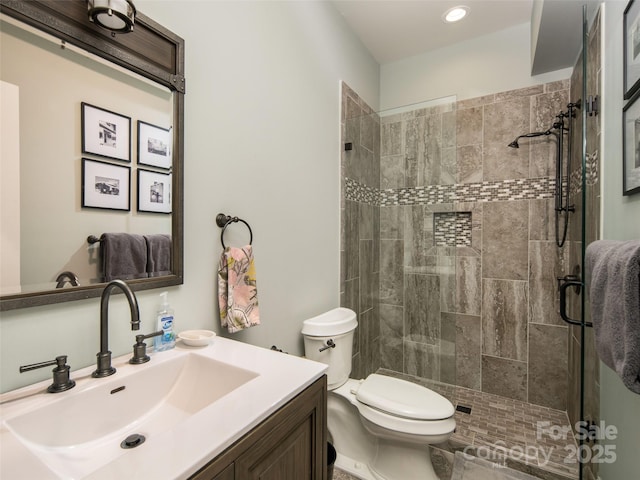 bathroom with vanity, a shower with shower door, and toilet