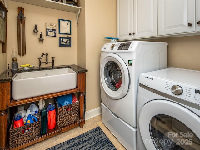 laundry area with sink, light tile patterned floors, cabinets, and washing machine and clothes dryer