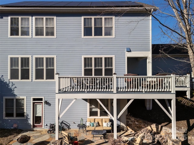 rear view of house with outdoor lounge area, a patio, and solar panels