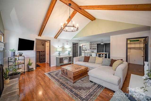 living room featuring hardwood / wood-style flooring, beamed ceiling, high vaulted ceiling, and a chandelier