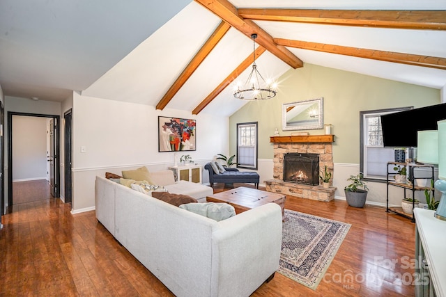 living room with dark hardwood / wood-style flooring, vaulted ceiling with beams, a notable chandelier, and a fireplace