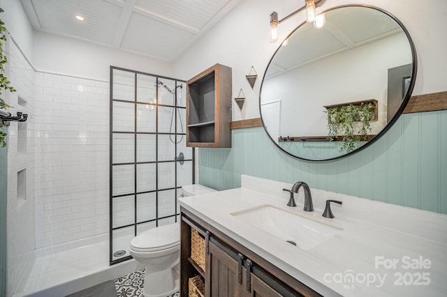 bathroom featuring vanity, toilet, and a tile shower