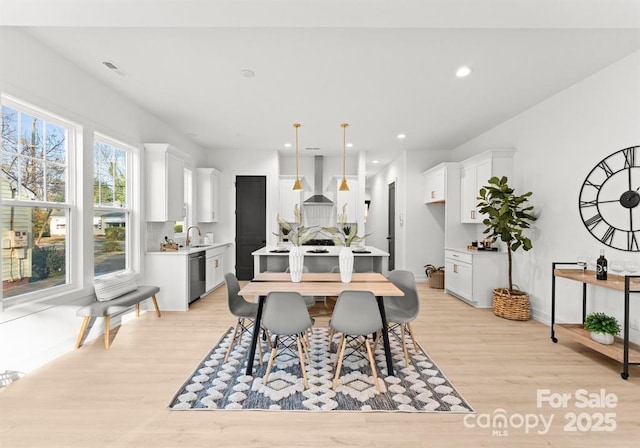 dining area featuring sink and light wood-type flooring