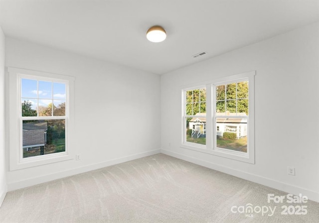 unfurnished room with baseboards and light carpet