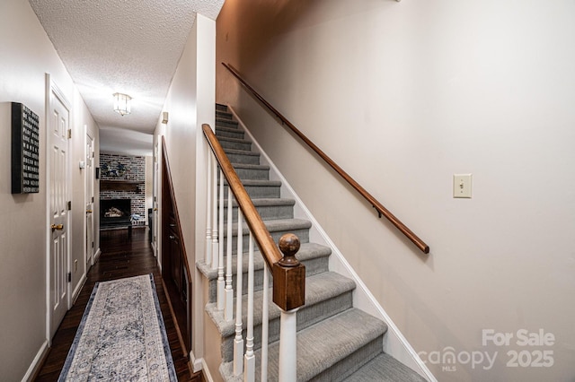 stairs featuring hardwood / wood-style flooring and a textured ceiling