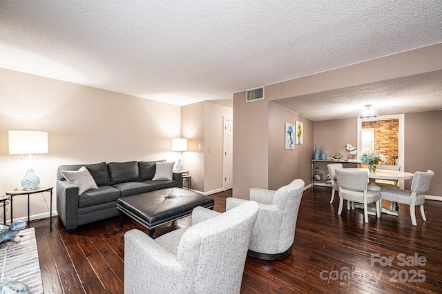 living room with dark hardwood / wood-style floors and a textured ceiling