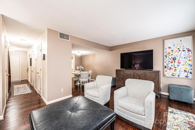 living room featuring dark hardwood / wood-style flooring and a textured ceiling