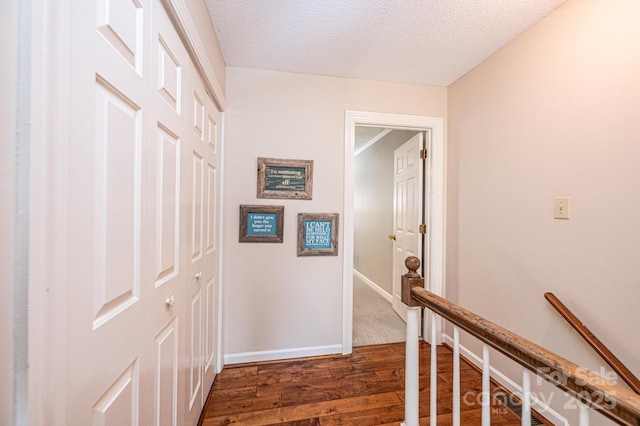 hallway featuring dark hardwood / wood-style floors and a textured ceiling