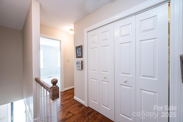 hallway featuring dark hardwood / wood-style flooring and a textured ceiling