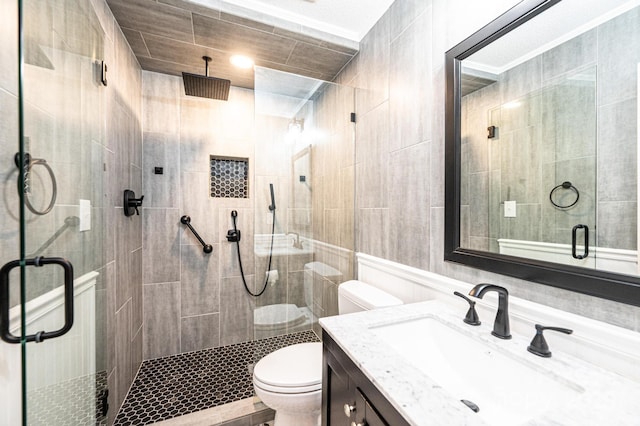 bathroom with vanity, a shower with door, and toilet