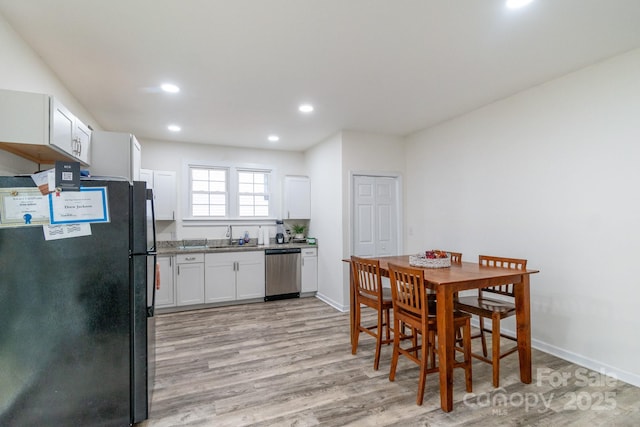 dining room featuring sink and light wood-type flooring