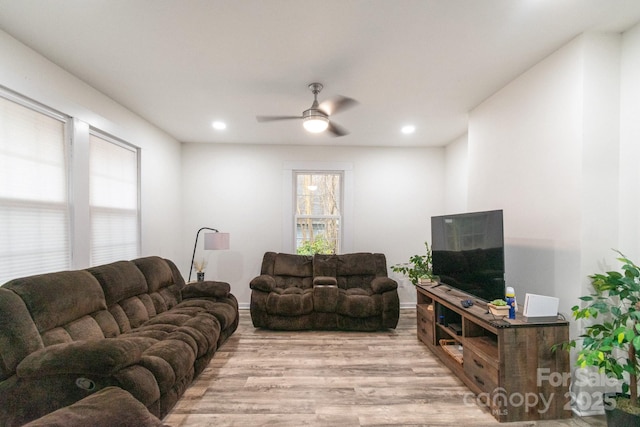 living room featuring ceiling fan, a healthy amount of sunlight, and light wood-type flooring