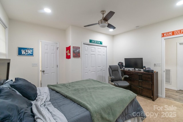 carpeted bedroom with ceiling fan and a closet