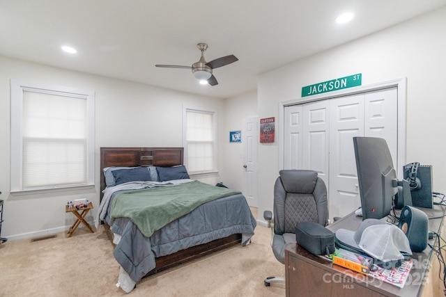 bedroom featuring ceiling fan, a closet, and light carpet