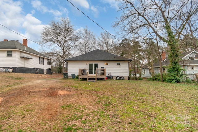 back of property with a deck and a lawn