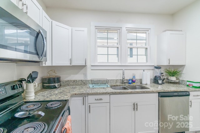 kitchen with white cabinetry, stainless steel appliances, and sink