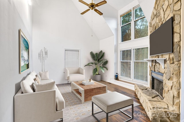 living room featuring ceiling fan, high vaulted ceiling, and a fireplace