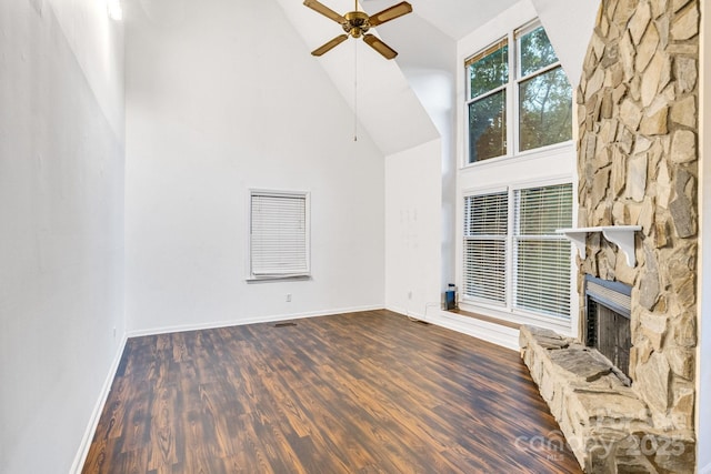 unfurnished living room featuring dark wood-type flooring, a fireplace, high vaulted ceiling, and ceiling fan