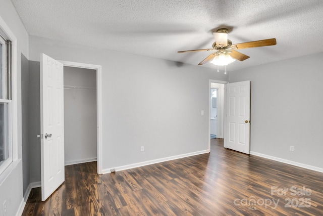 unfurnished bedroom with ceiling fan, dark wood-type flooring, a textured ceiling, and a closet