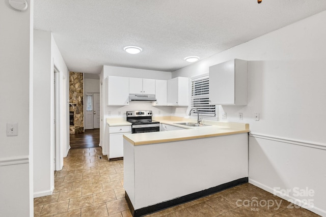 kitchen featuring white cabinetry, sink, stainless steel range with electric cooktop, kitchen peninsula, and a textured ceiling