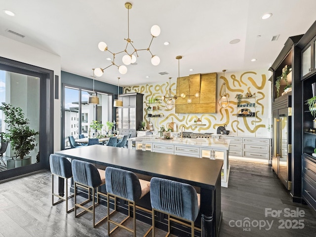 kitchen with decorative light fixtures, a kitchen breakfast bar, and dark hardwood / wood-style floors