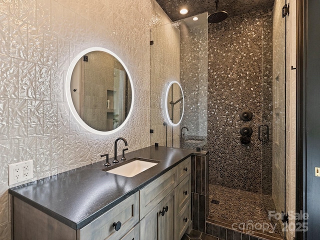 bathroom featuring vanity, tile walls, and walk in shower