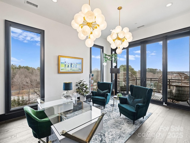 interior space with an inviting chandelier and light hardwood / wood-style flooring