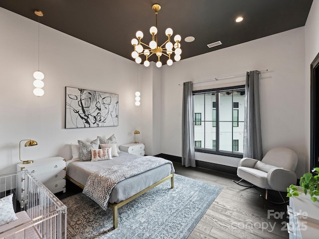 bedroom featuring hardwood / wood-style floors and a chandelier