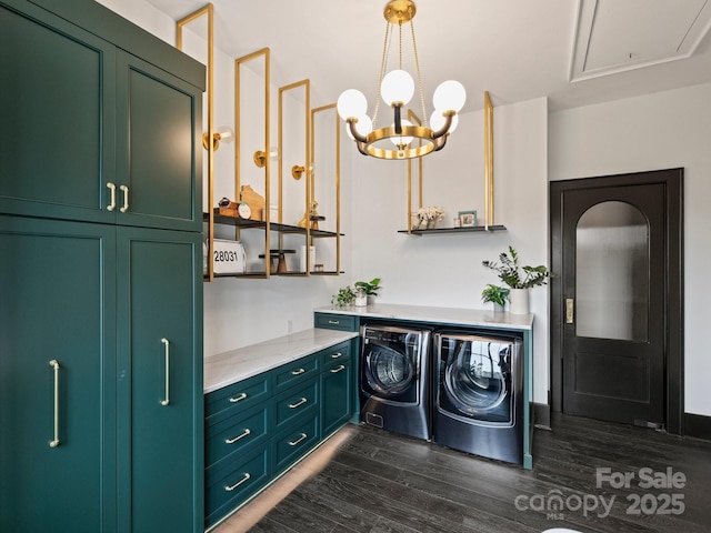 laundry room with cabinets, dark hardwood / wood-style flooring, a chandelier, and washing machine and dryer