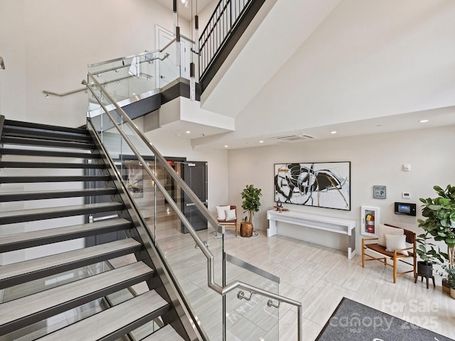 staircase featuring a towering ceiling