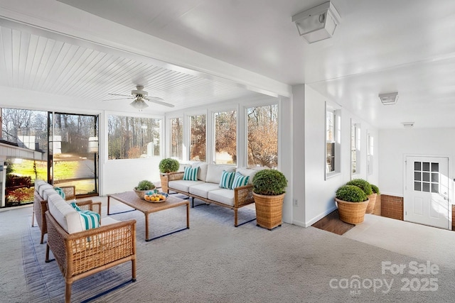 sunroom featuring beamed ceiling and ceiling fan