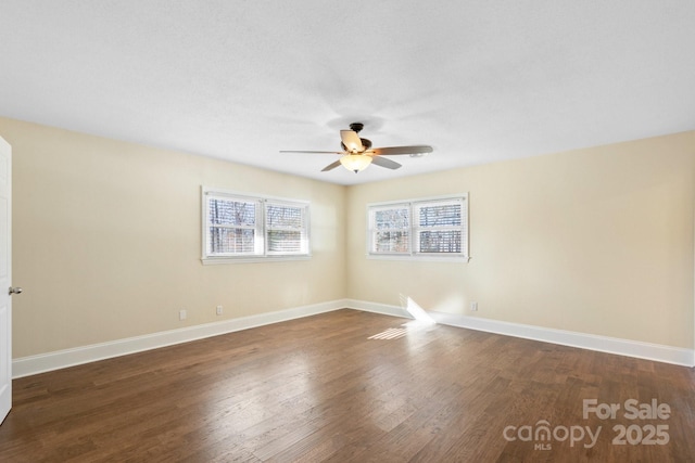 spare room featuring dark wood-type flooring and ceiling fan