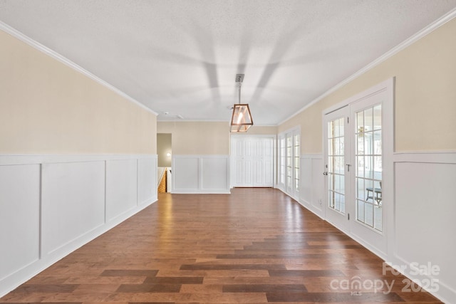 spare room with crown molding, a textured ceiling, dark hardwood / wood-style flooring, and french doors