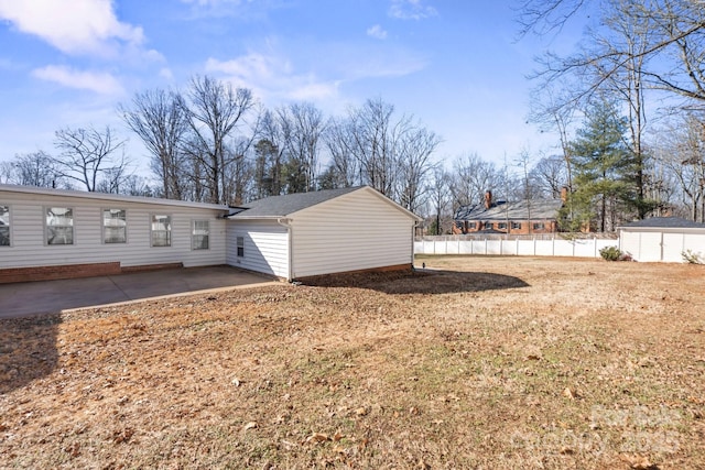 back of property with a yard, a patio, and a storage unit