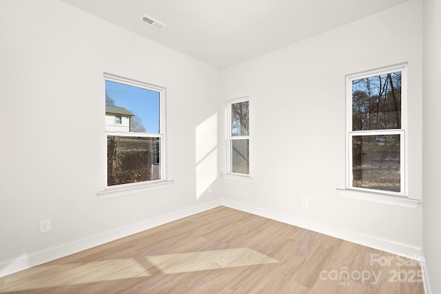 unfurnished room with plenty of natural light and light hardwood / wood-style floors