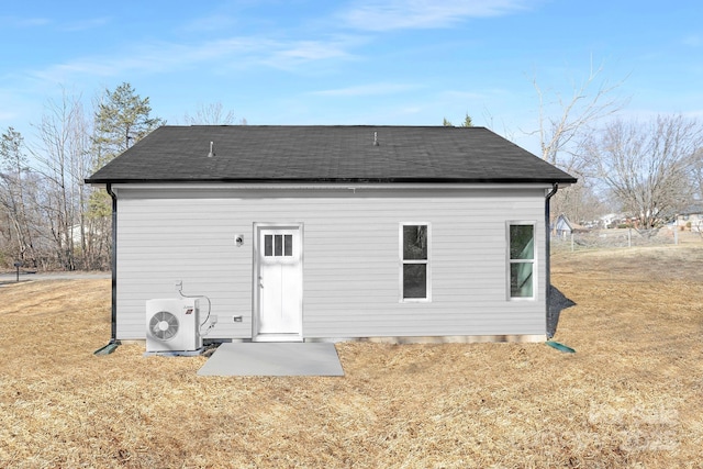 rear view of property with ac unit and a lawn