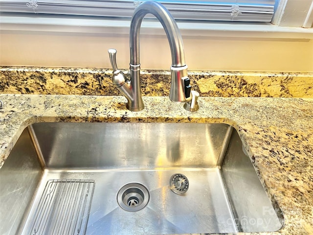 room details featuring stone counters and a sink