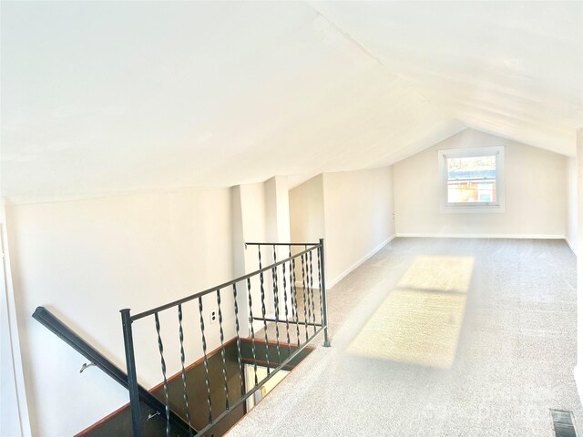 bonus room with lofted ceiling, carpet, visible vents, and baseboards