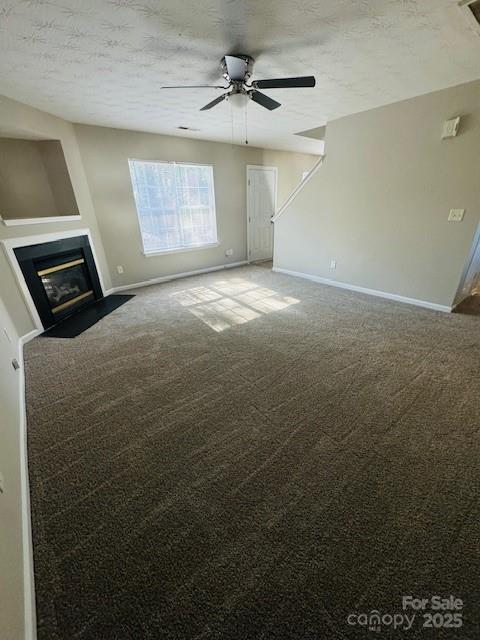 unfurnished living room with ceiling fan, carpet, and a textured ceiling