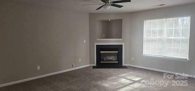 unfurnished living room featuring ceiling fan, carpet flooring, and a textured ceiling