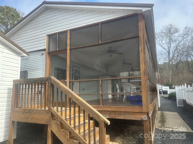 deck with ceiling fan and a sunroom