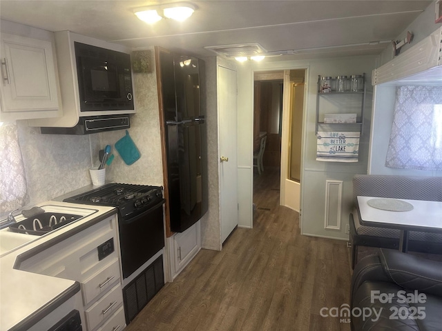 kitchen featuring white cabinetry, decorative backsplash, dark hardwood / wood-style flooring, and black appliances