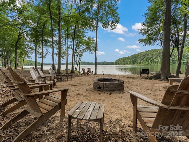 view of property's community featuring a water view and an outdoor fire pit