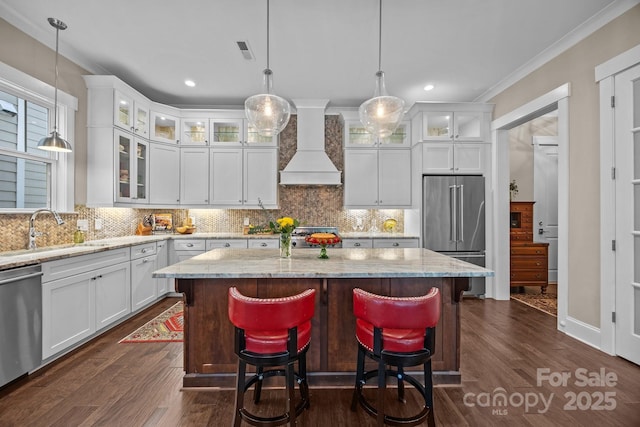 kitchen with premium range hood, sink, white cabinets, a center island, and stainless steel appliances