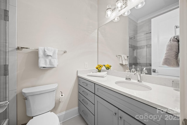 bathroom featuring a shower with door, vanity, and toilet