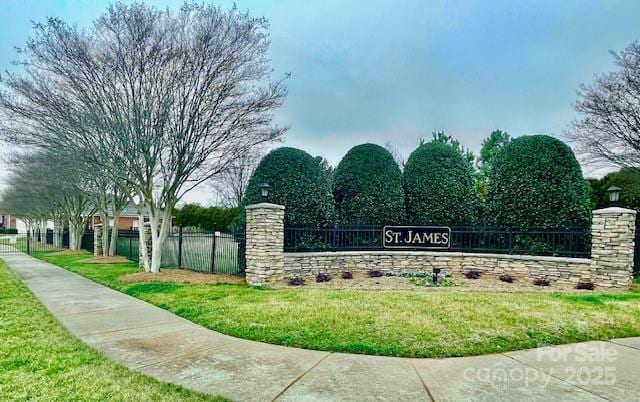 community / neighborhood sign featuring a yard and fence