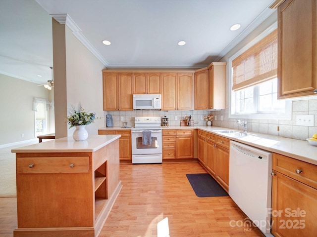 kitchen with white appliances, light wood-style flooring, a sink, light countertops, and crown molding