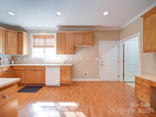 kitchen with light wood-style flooring, light countertops, crown molding, and white dishwasher