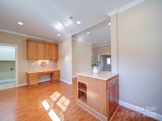 kitchen featuring visible vents, light wood-style flooring, decorative backsplash, light countertops, and built in desk