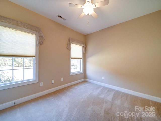 carpeted spare room featuring ceiling fan